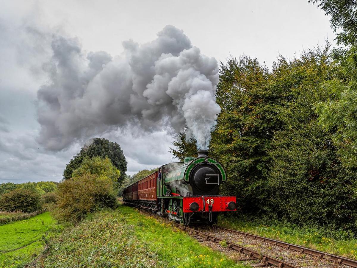 a large long train on a track with smoke coming out of it