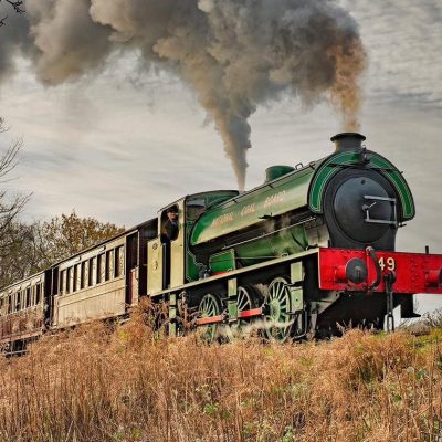 a steam engine on a train track with smoke coming out of it