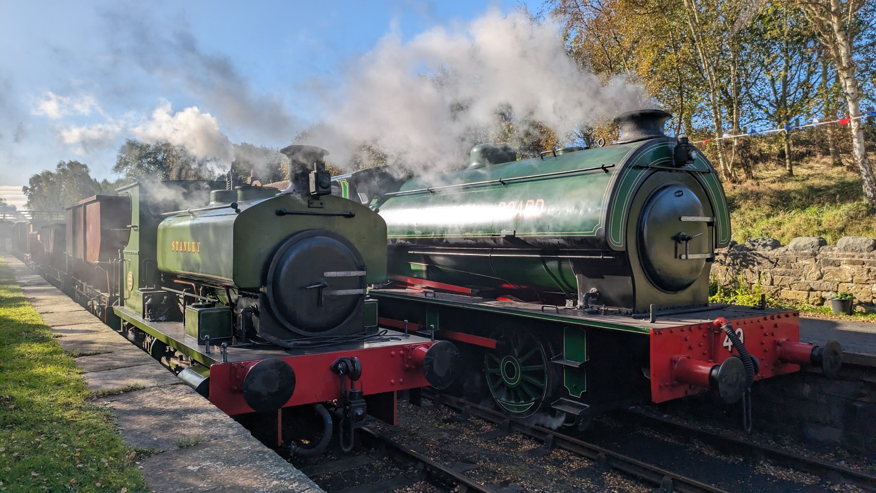 a steam engine is sitting on a train track with smoke coming from it