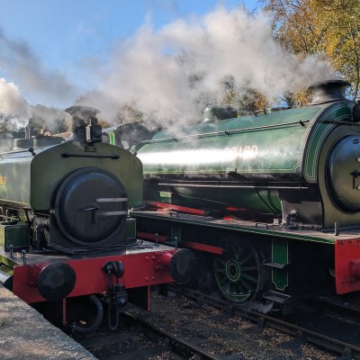 a steam engine is sitting on a train track with smoke coming from it