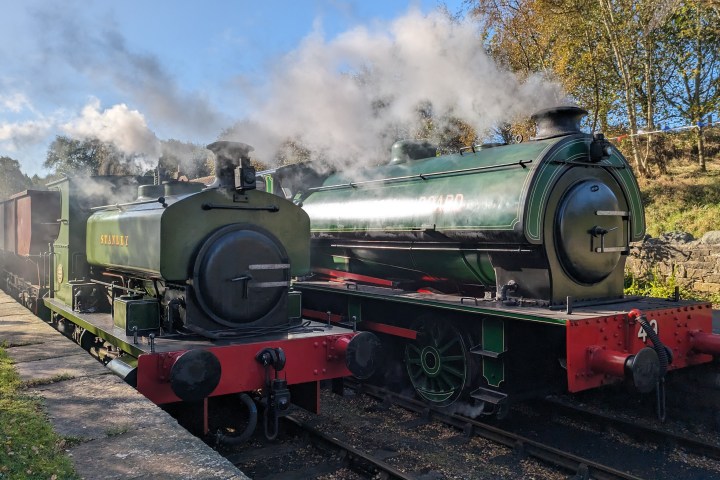 a steam engine is sitting on a train track with smoke coming from it