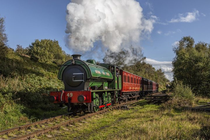 a steam train on a track with smoke coming out of it