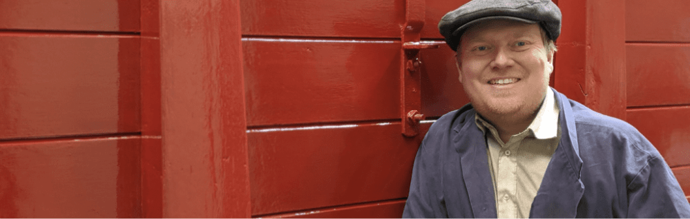 a man wearing a hat and smiling at the camera