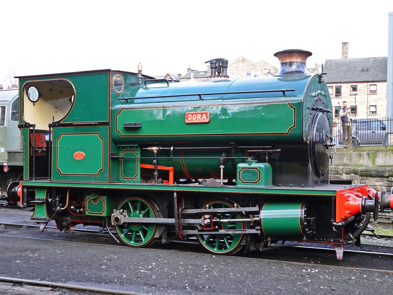 Vintage green steam locomotive named Dora on a railway track.