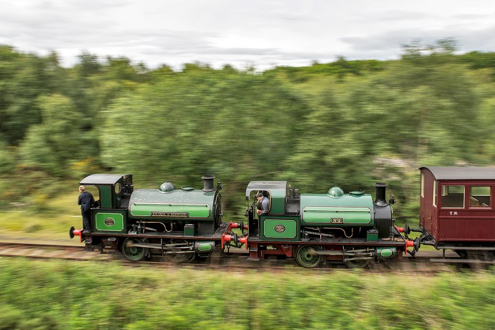 a train traveling down train tracks near a forest