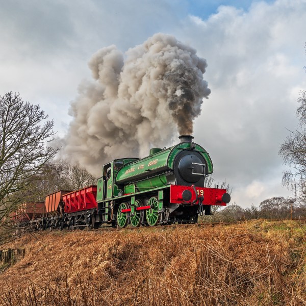 a train on a track with smoke coming out of it